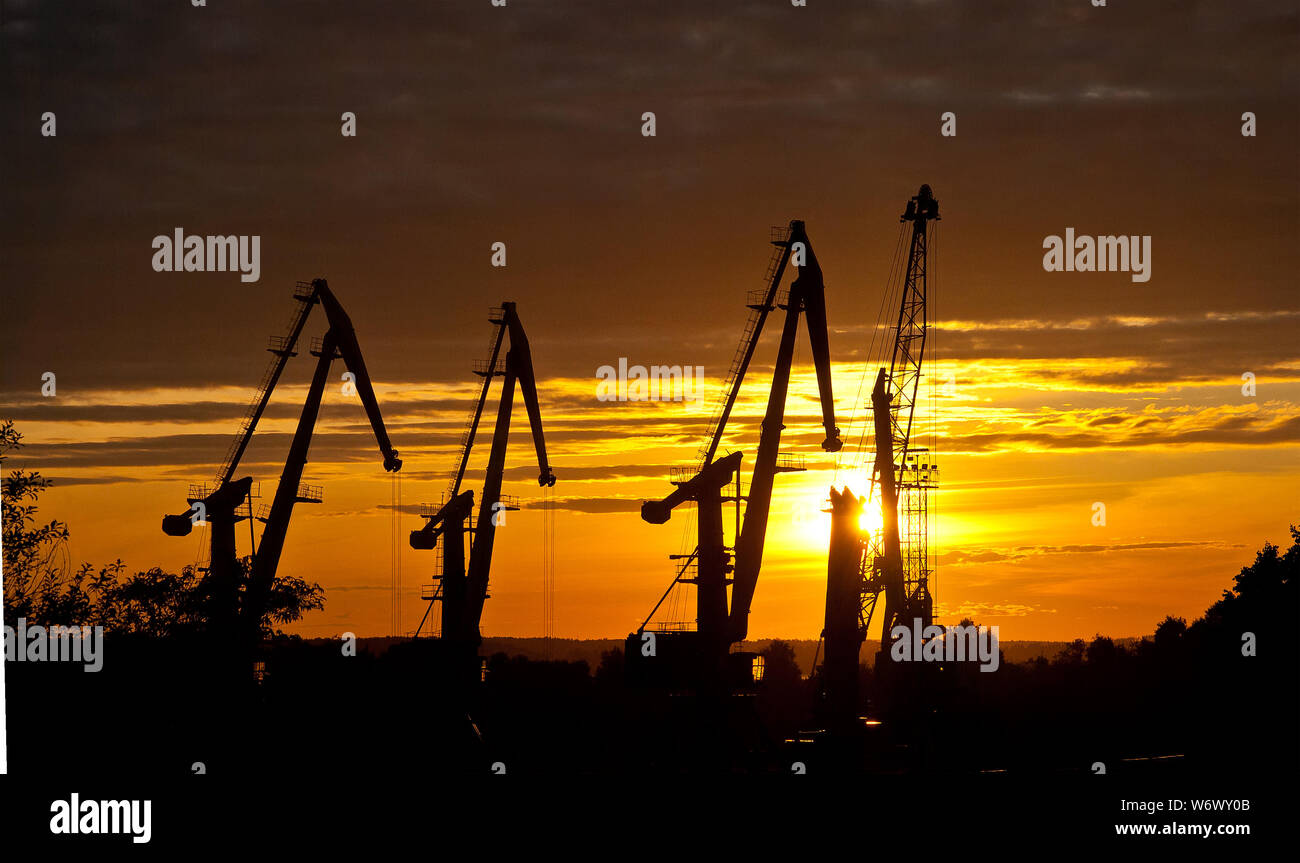 silhouette of harbor cranes on sunset sky background Stock Photo - Alamy