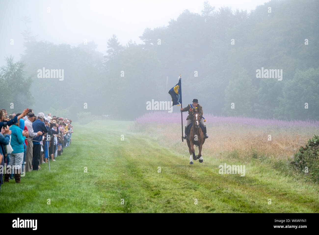 Lauder, SCOTLAND - August 03: Lauder Common Riding 2019. Christopher Purves, Lauder Cornet 2019 with the Burgh Standard galloping up the Golf Course at the start of the ride out. Lauder Common Riding is part of a tradition of Common Ridings and similar festivals in the Borders and south of Scotland. The main event is a Riding of over 300 horses around the Common land of Lauder. The main Rideout is always the first Saturday in August and is the culmination of a whole week of events. Lauder Common Riding is proud to be one of the original and oldest Border Common Ridings. Stock Photo