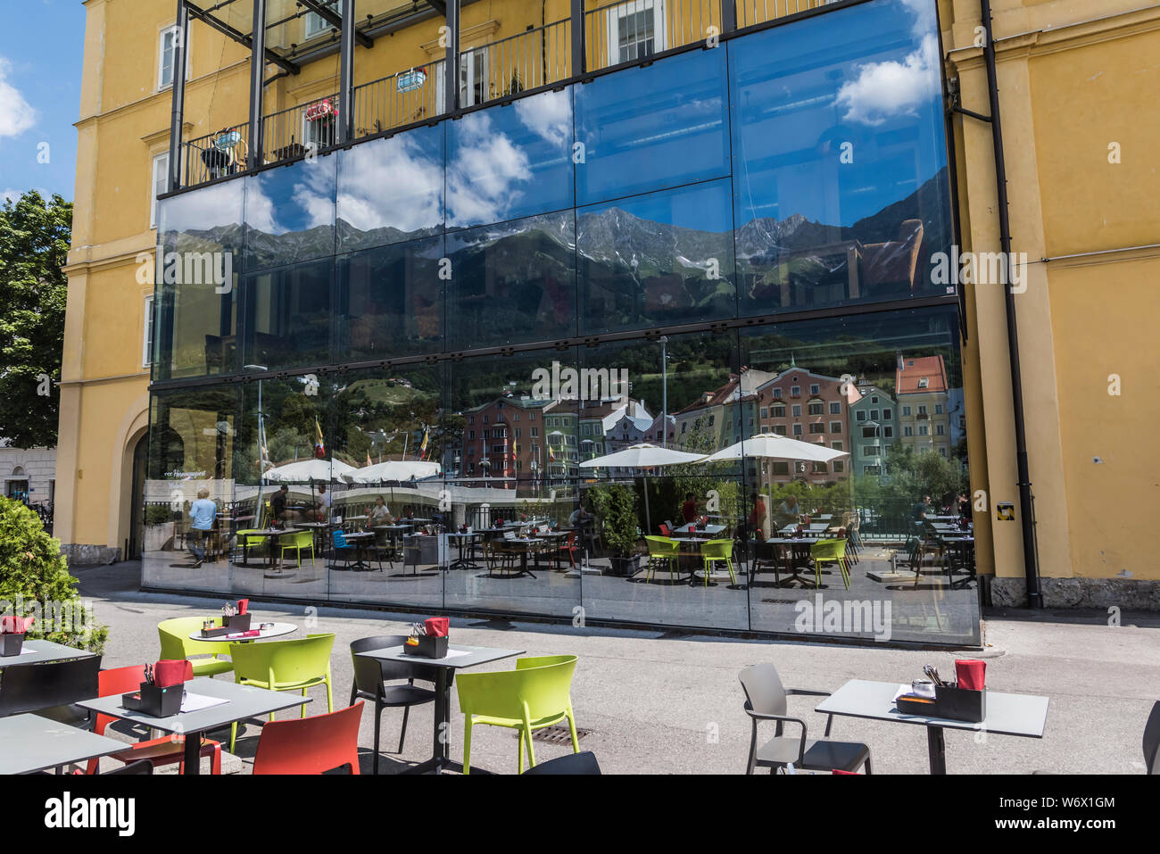 Window reflections of people enjoying themselves during a sunny summer day in the city Innsbruck provincial capitol city of the Tirol in Austria Stock Photo