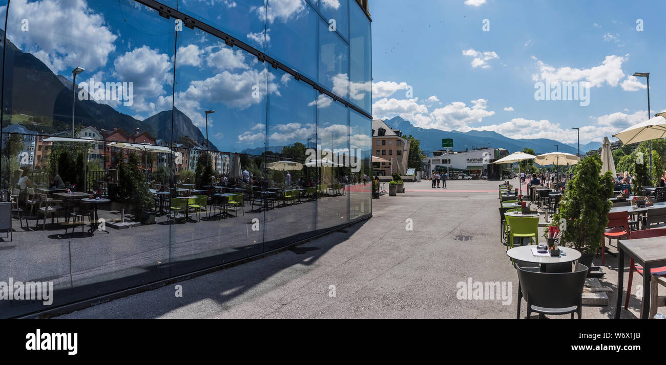 Window reflections of people enjoying themselves during a sunny summer day in the city Innsbruck provincial capitol city of the Tirol in Austria Stock Photo