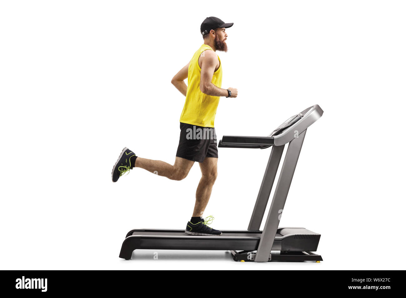 Full length profile shot of a bearded man running on a treadmill isolated on white background Stock Photo