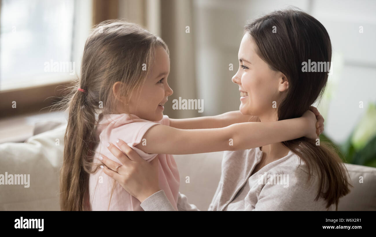 Side view lovely daughter and loving mother embracing showing love Stock Photo