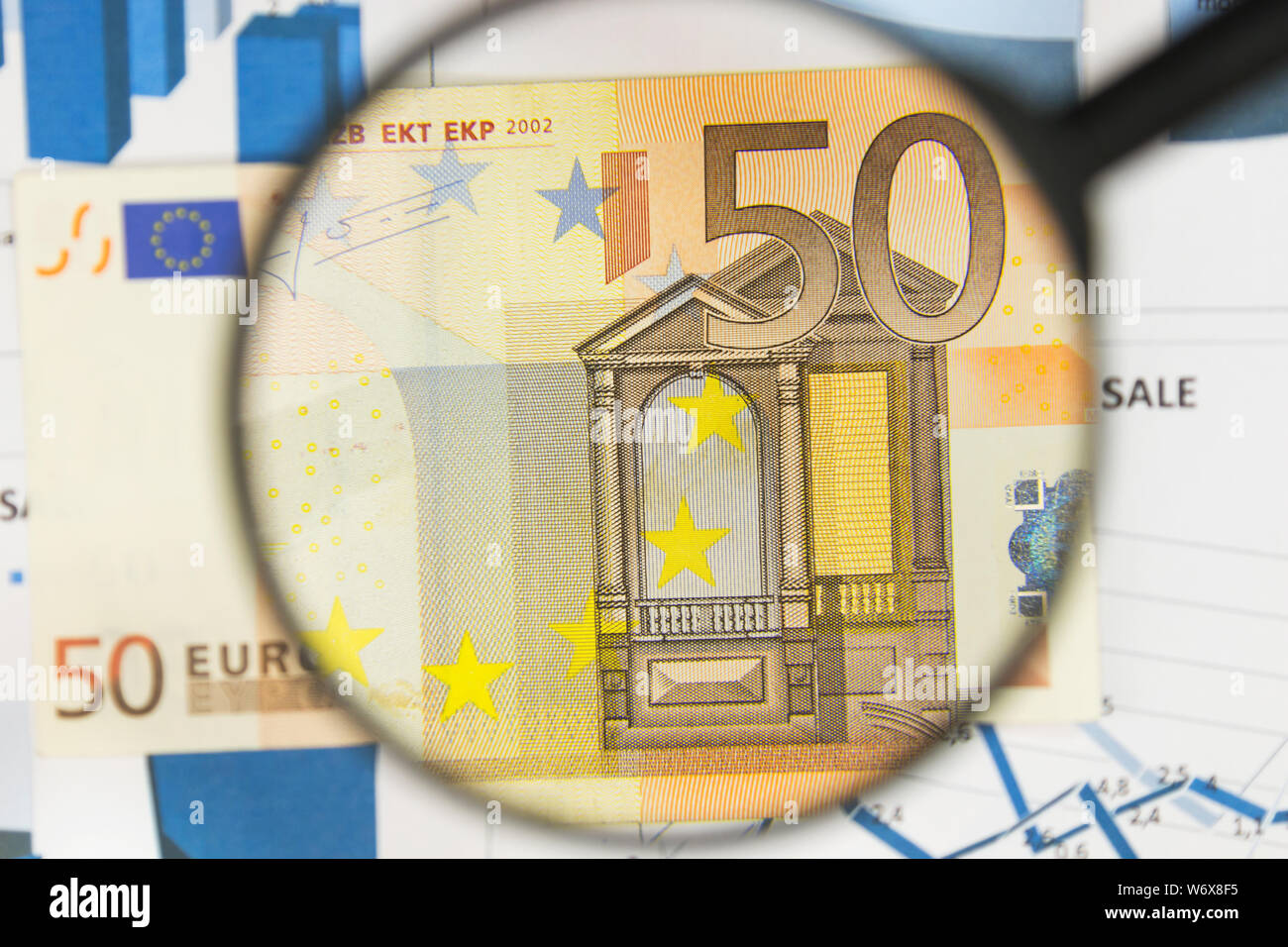 Close-up of fifty euros through a magnifying glass. Business background. Money research concept. Top view Stock Photo