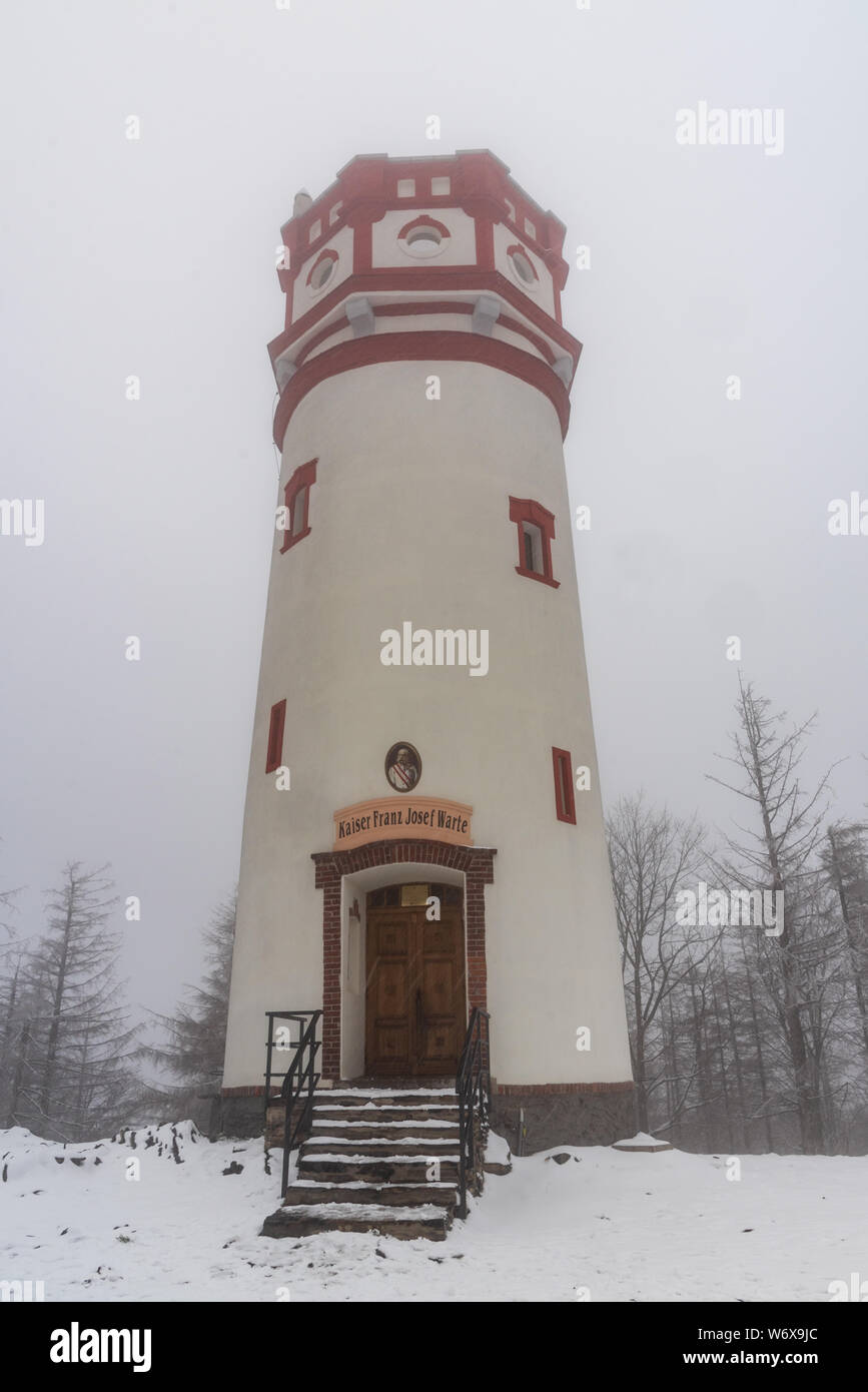 view tower on Biskupska kupa hill above Zlate Hory town on czech-polish borders during april day with snow Stock Photo