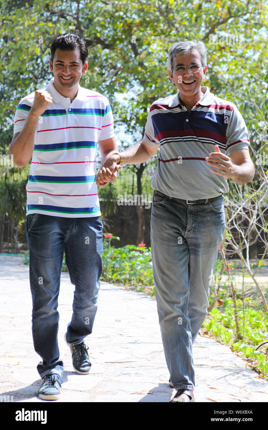 Senior man walking with his adult son in a park Stock Photo