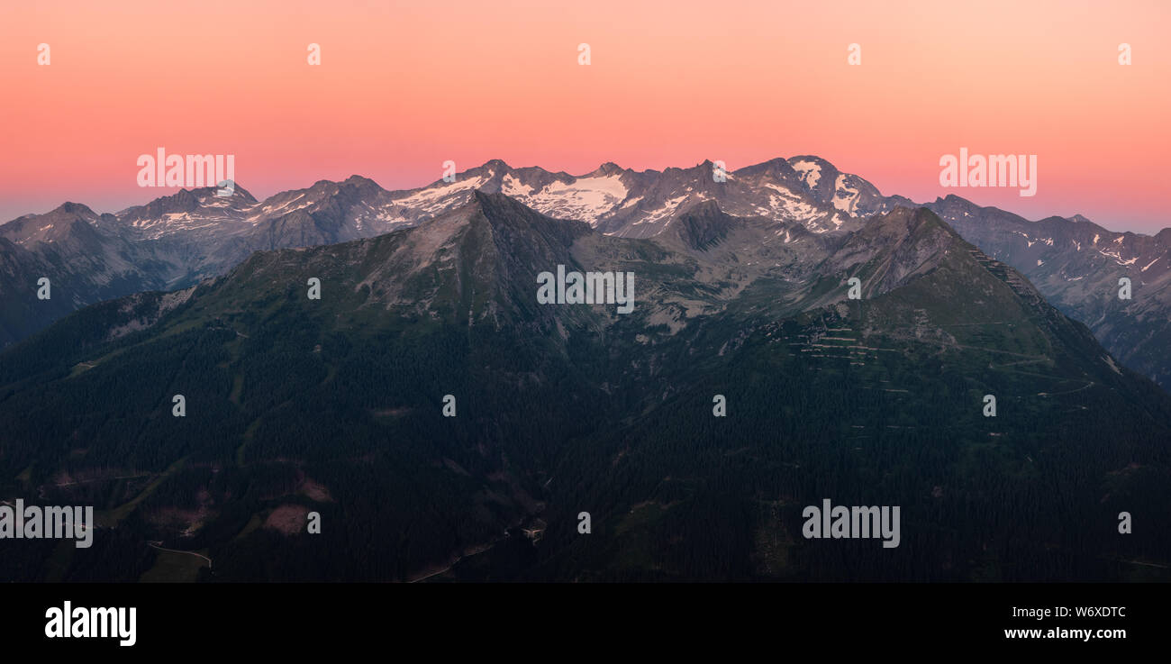 Scenic panorama mountain landscape with orange sunset at summer evening in Austria alps. Stock Photo
