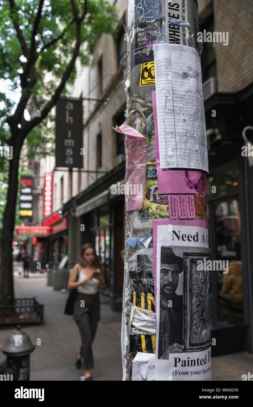 New York urban, view of a street light in Thompson Street heavily covered with stickers and