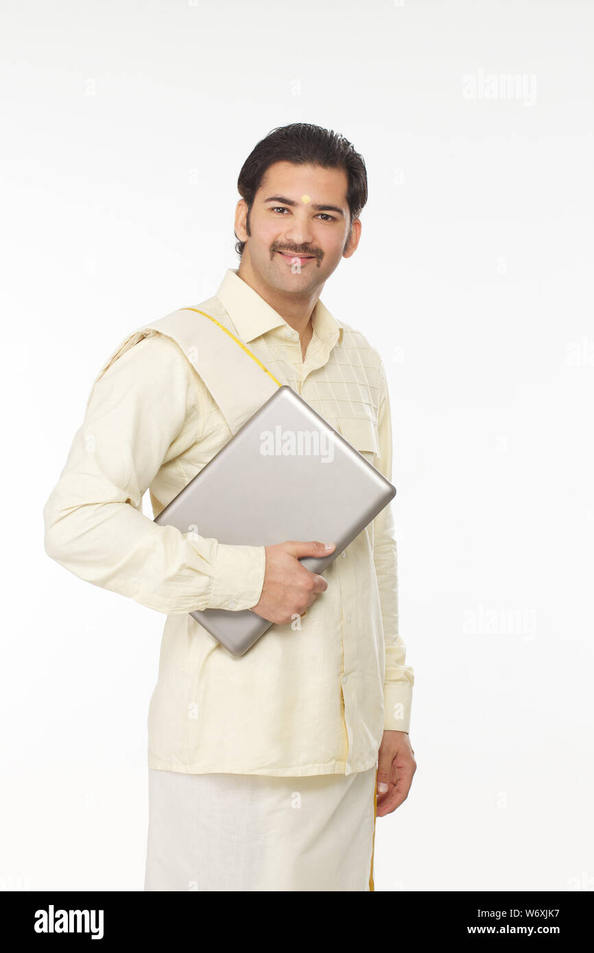 South Indian man holding a laptop Stock Photo