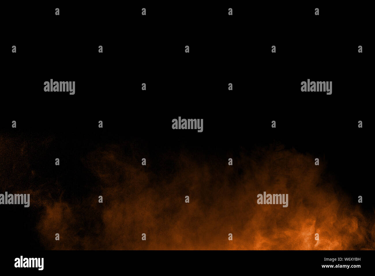 Abstract orange powder explosion on black background. Freeze motion of ...