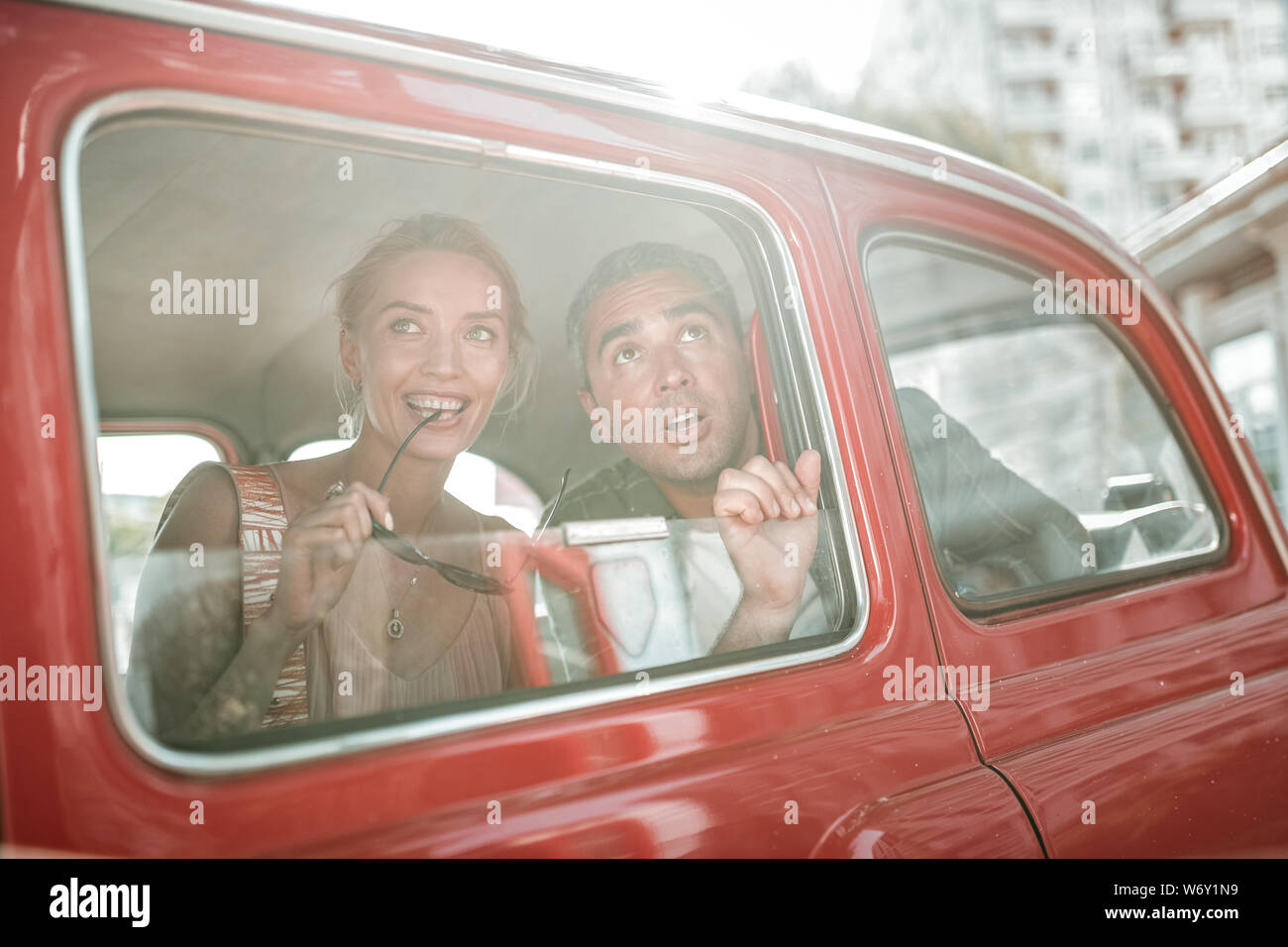 Amazed tourists looking out of the car window. Stock Photo