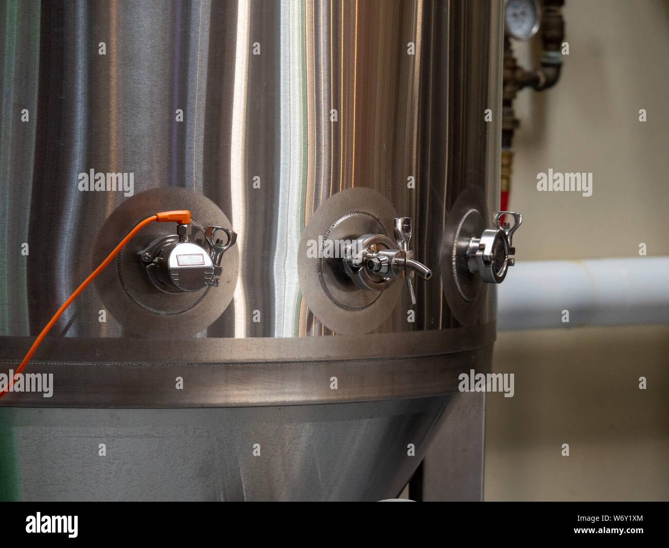 Stainless steel fermentation tank producing beer at a brewery Stock Photo