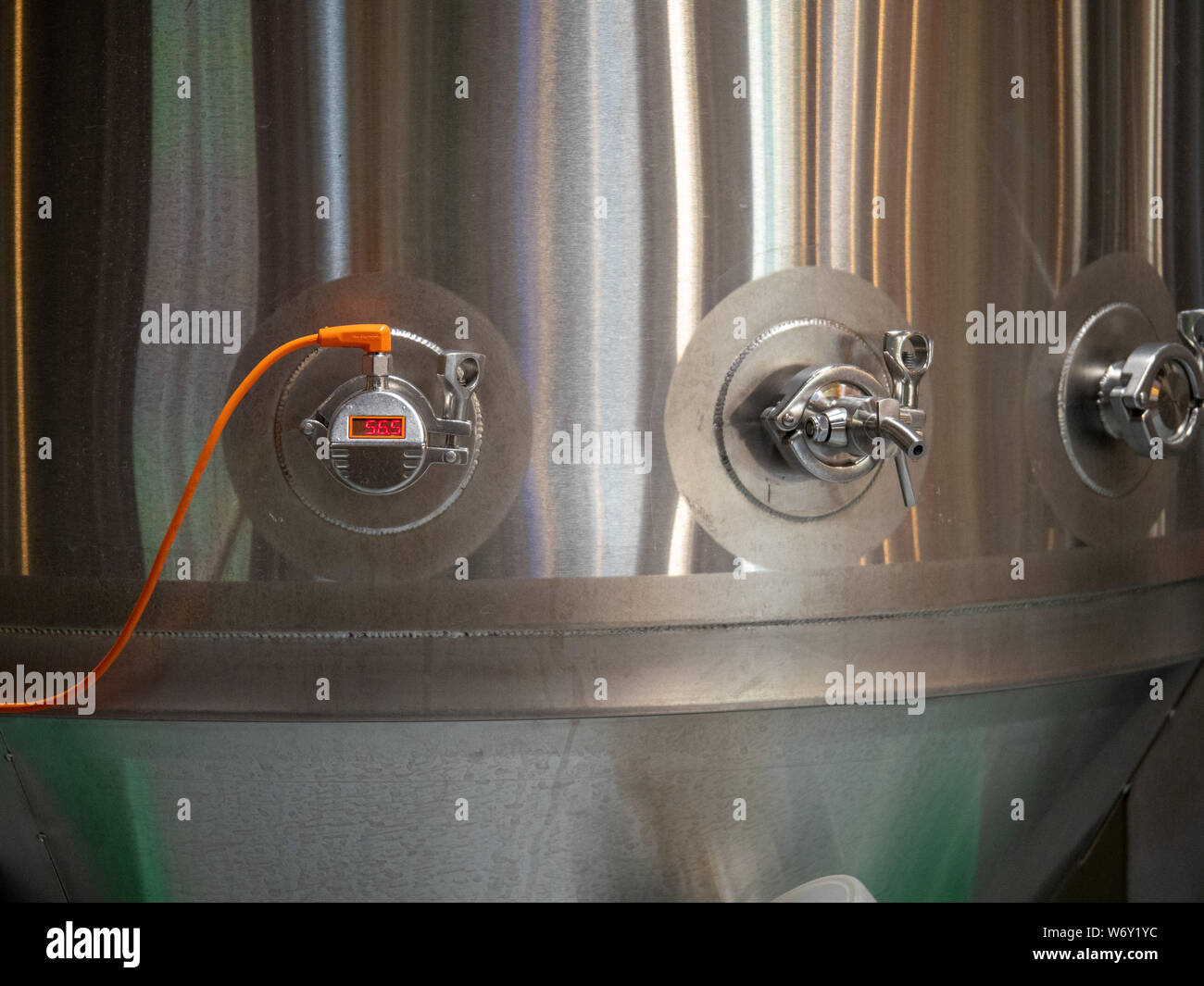Tubes running into large steel fermentation tank in brewery Stock Photo