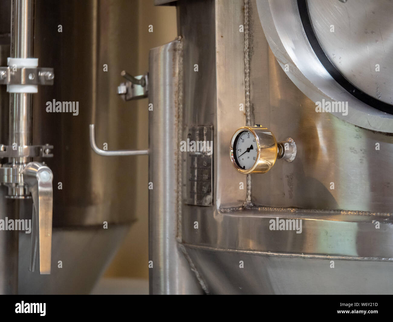 PSI gauge at low pressure on fermentation tank in busy brewery Stock Photo