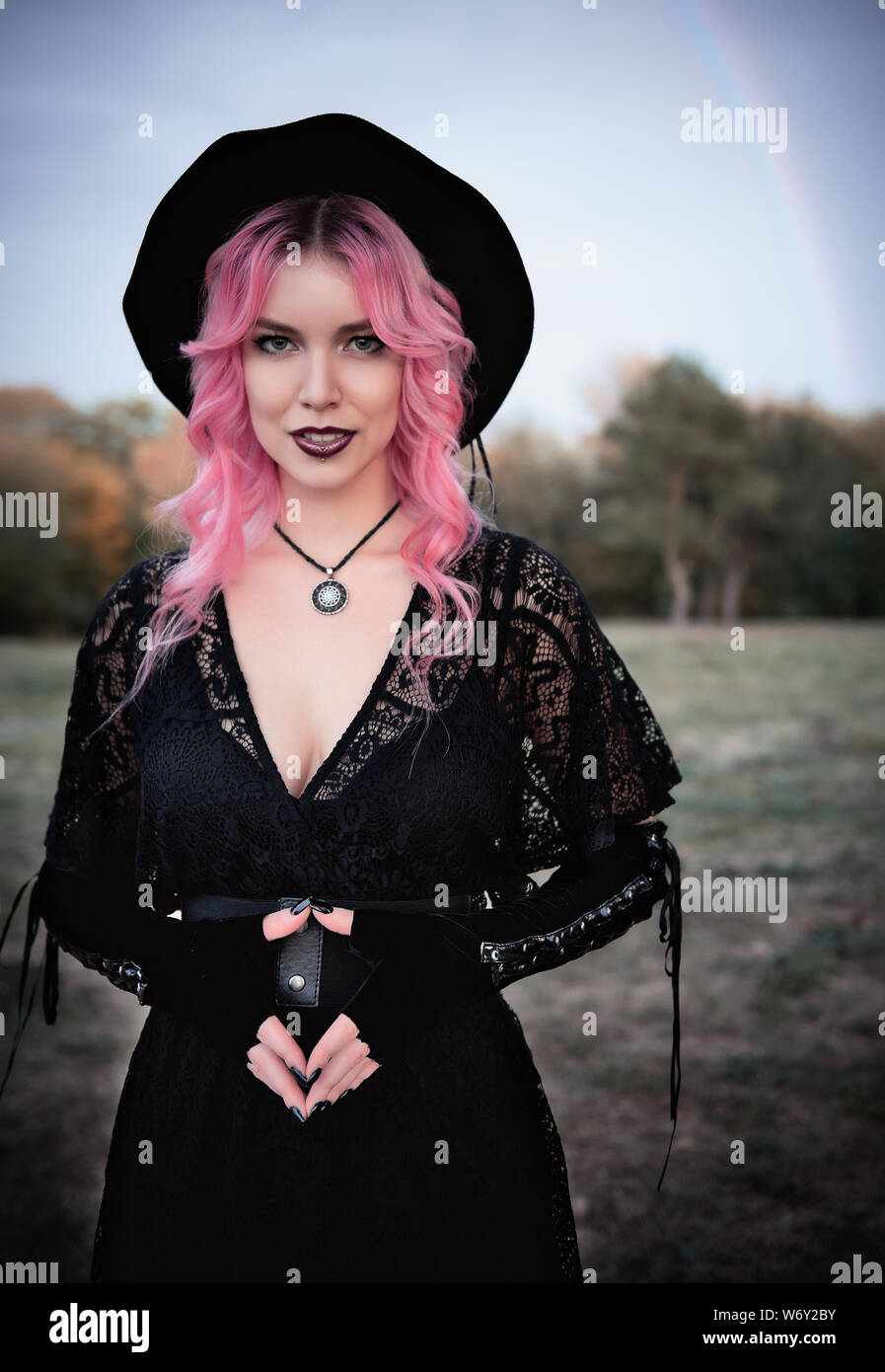 Halloween theme: contemporary cute young witch in black dress and hat. Halloween theme Stock Photo