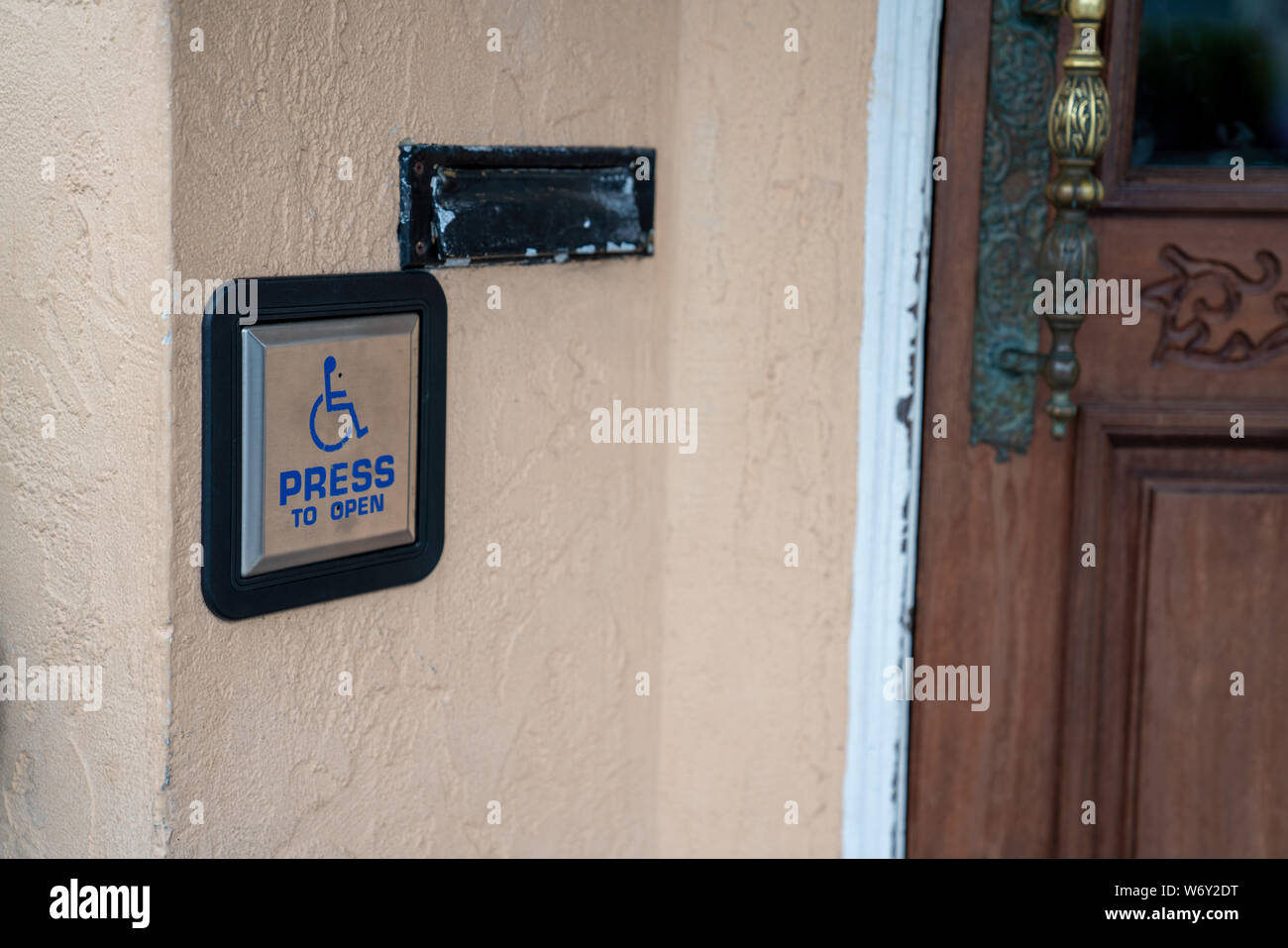 Press to open handicap button disability accessibility outside of door entrance Stock Photo