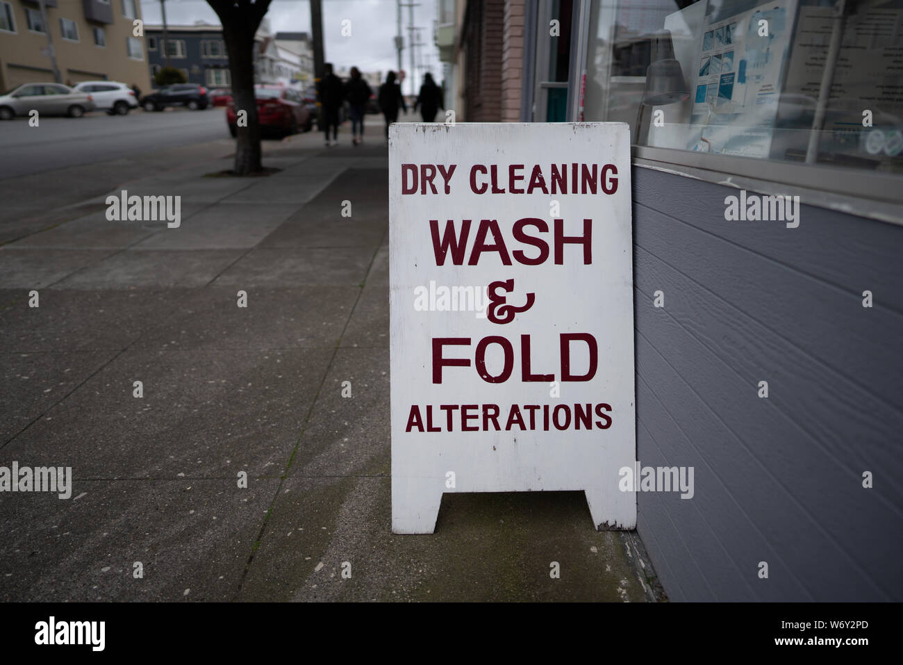 Dry cleaning wash and fold alterations signboard outside of store on sidewalk Stock Photo