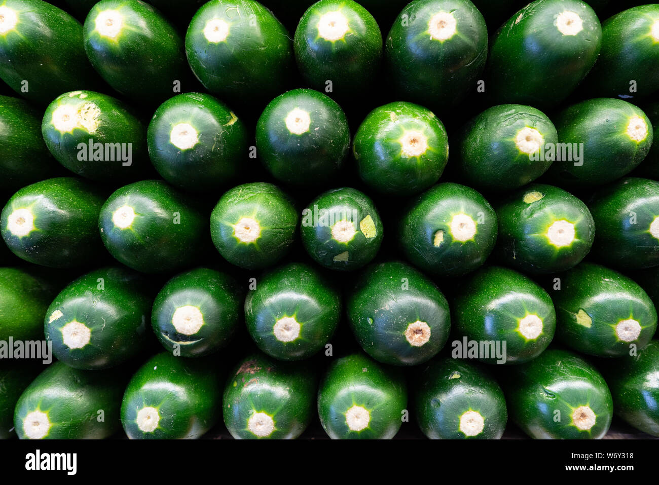 Cucumbers in a stack in produce section of grocery store Stock Photo