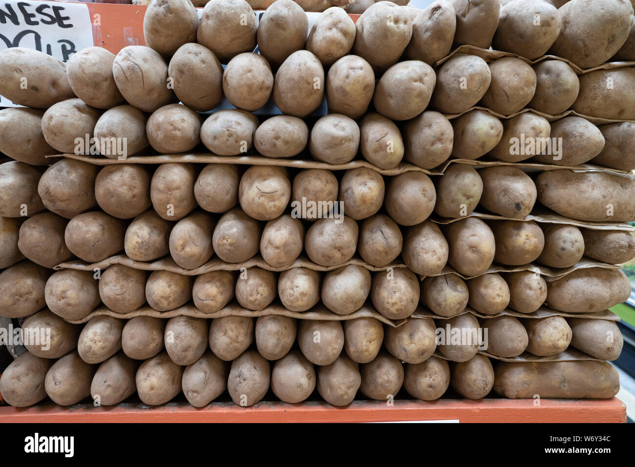 Russet potatoes piled high in produce section in clean supermarket
