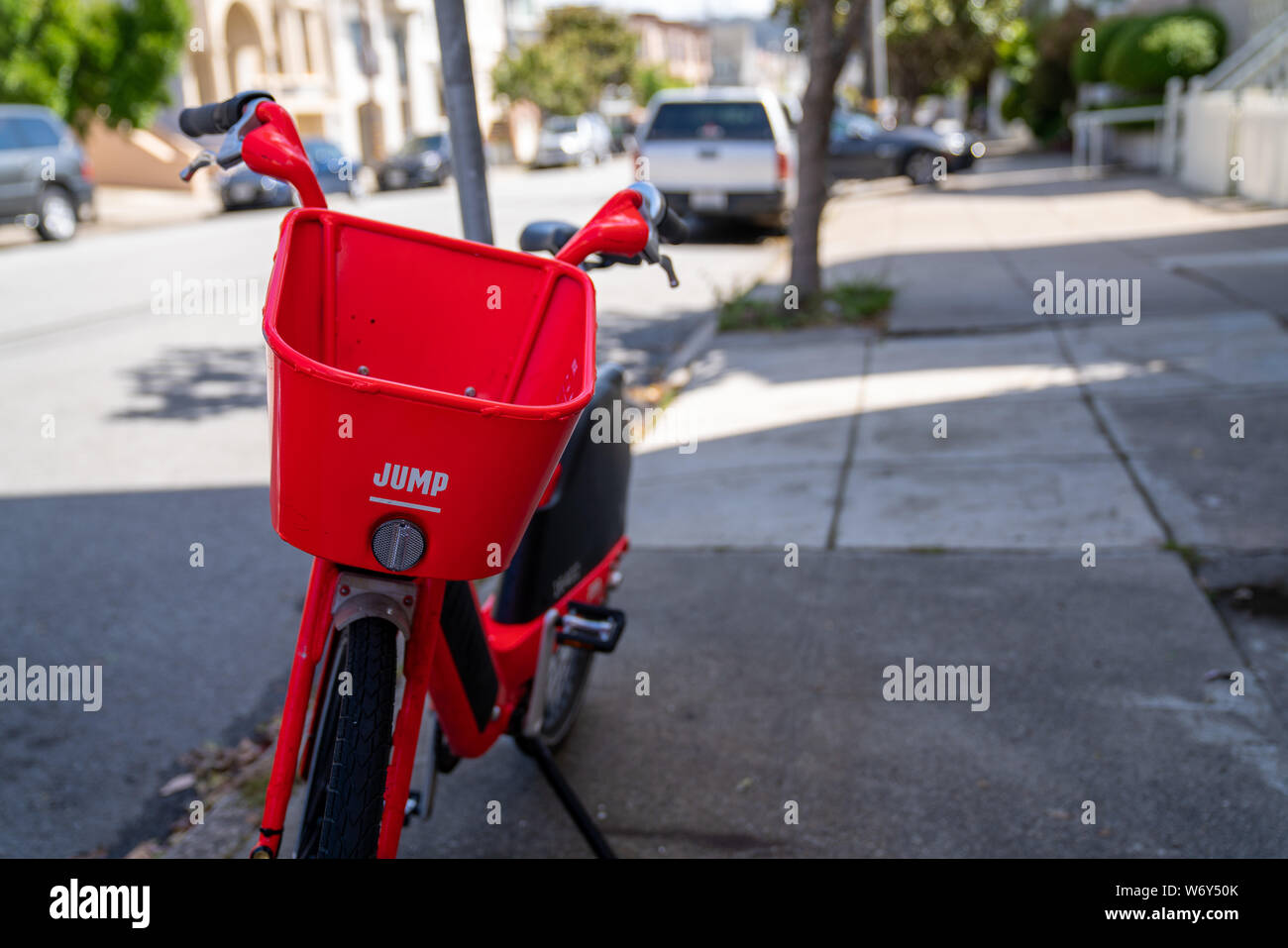Red JUMP on-demand electric bicycle, company owned by Uber, parked on residential street Stock Photo