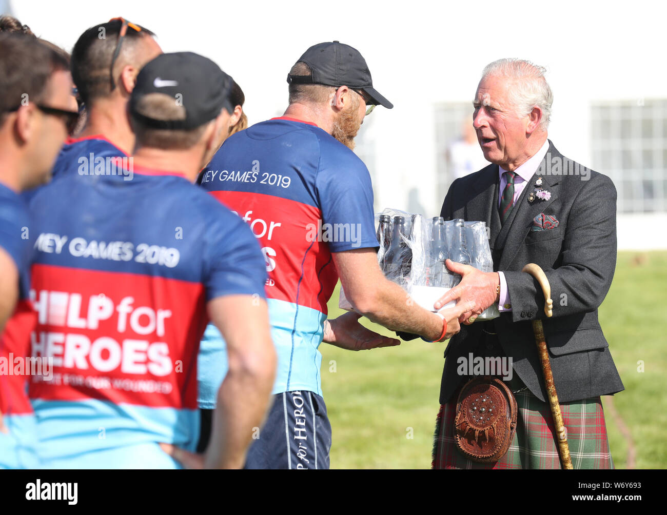 The Prince of Wales, known as the Duke of Rothesay while in Scotland, presents a prize of a case of beer to the Help for Heroes team who won the tug of war at the Mey Highland & Cultural Games at the John O'Groats Showground in Caithness. Stock Photo