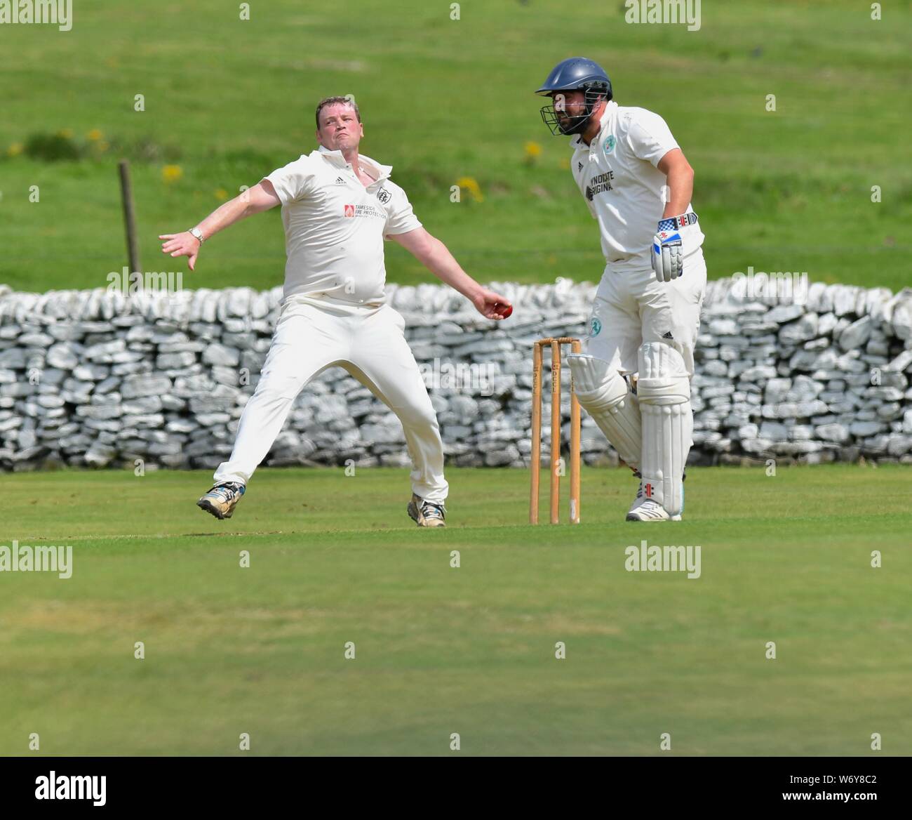 A fast bowler in action in the match between Old Glossop and Tintwistle Stock Photo