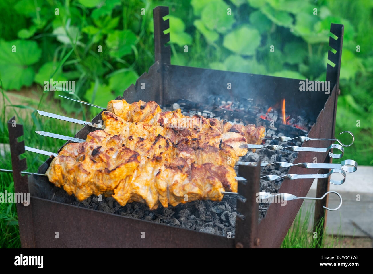 Shish kebab in process of cooking on open fire Stock Photo