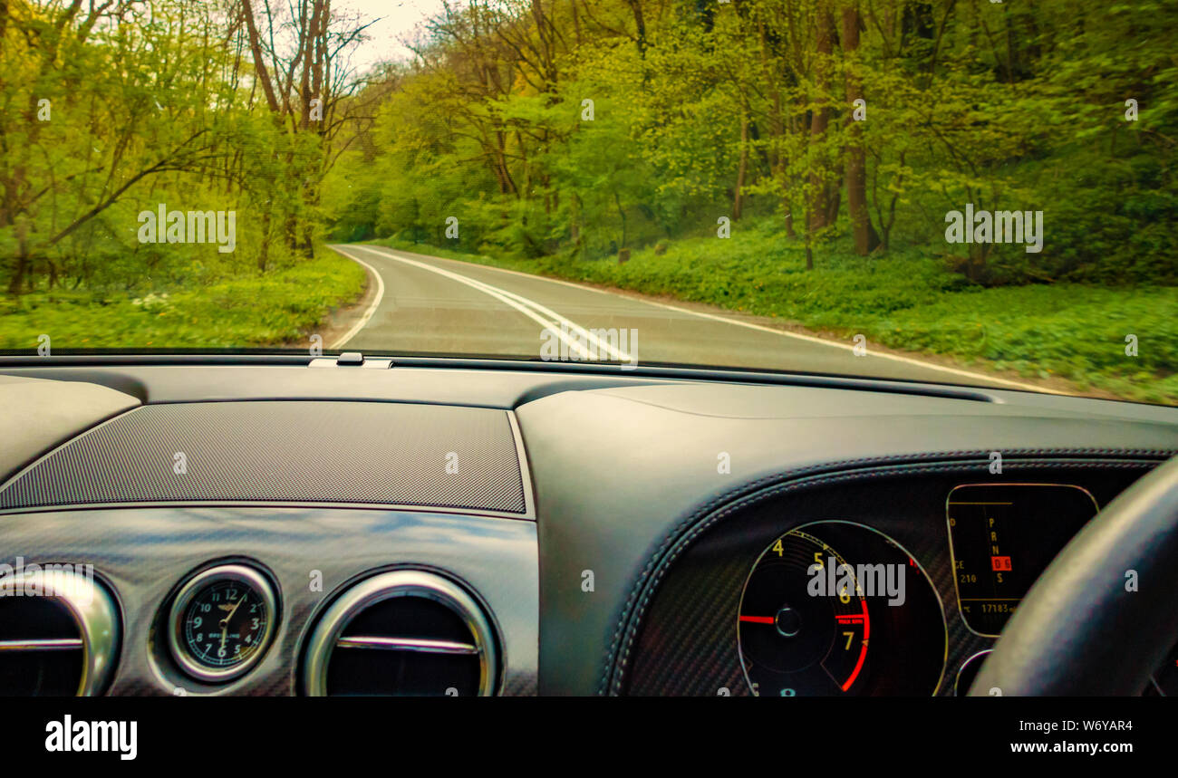 Country road as seen through the windscreen of a Bentley Continental GTC Supersport car Stock Photo