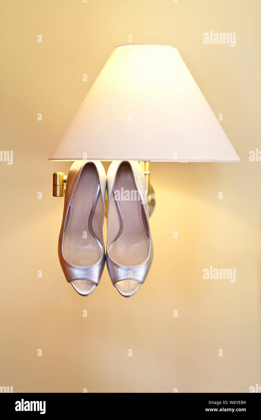 Silvery Wedding Shoes Hanging On The Ceiling Of The Beige