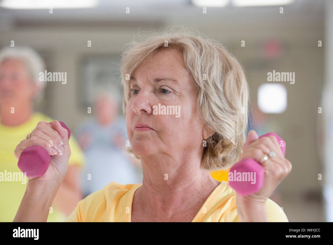 Senior woman exercising in gym Stock Photo