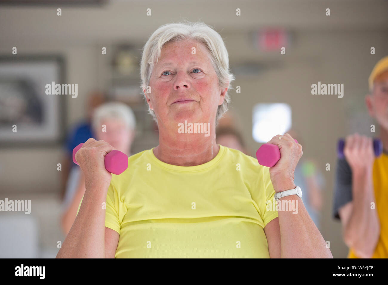 Happy senior woman exercising in gym Stock Photo