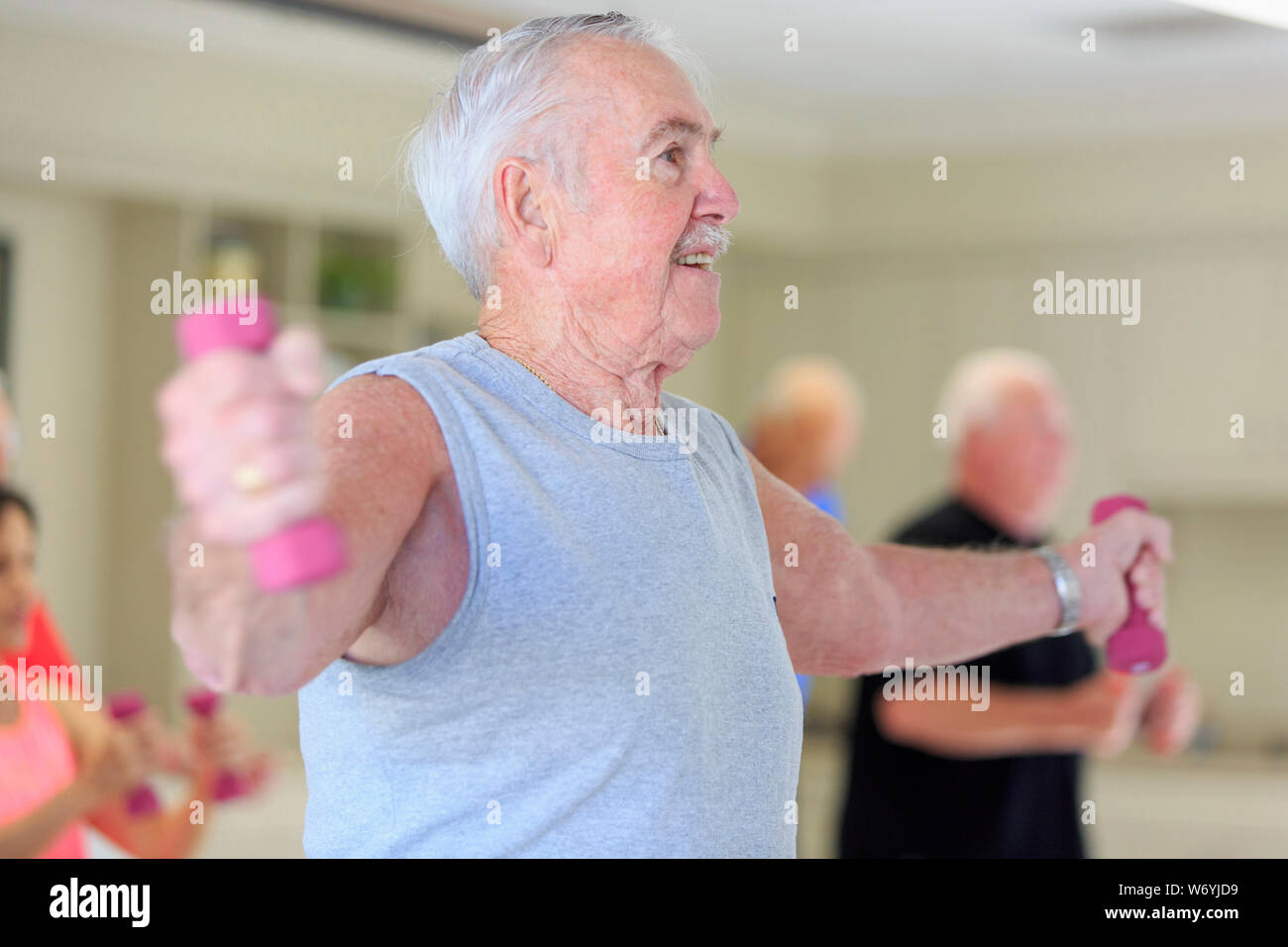 Happy senior man exercising in gym Stock Photo