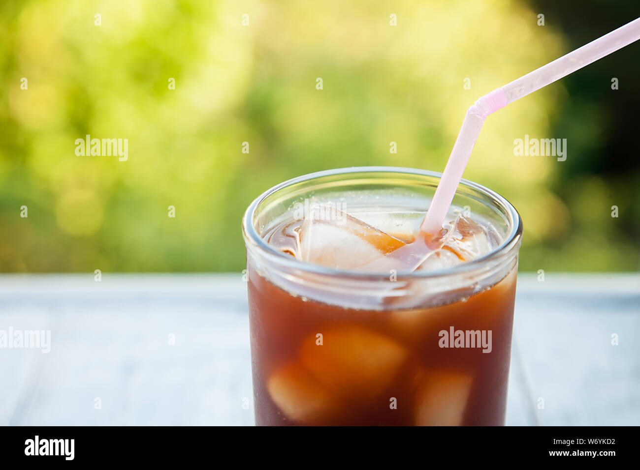 https://c8.alamy.com/comp/W6YKD2/close-up-of-an-ice-drink-with-ice-cube-in-a-glass-cup-on-a-natural-background-W6YKD2.jpg