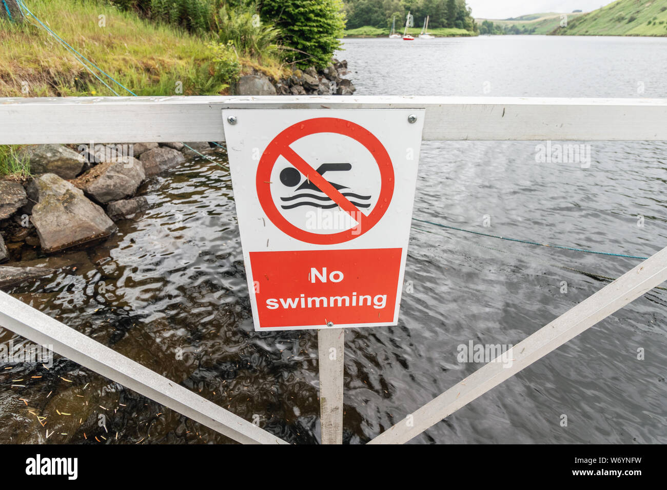 No swimming sign at a boating lake in Wales, in front of rippling water Stock Photo
