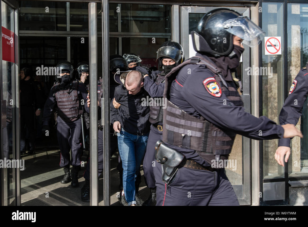 Police officers detain a man during an unsanctioned rally in the centre of Moscow, Russia.Moscow police detained more than 300 people who were protesting against the exclusion of some independent and opposition candidates from the city council ballot, a monitoring group said. Stock Photo