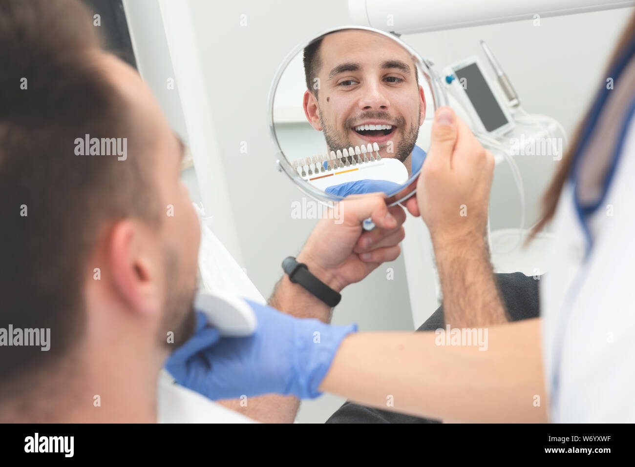 Handsome young man in stomatology clinic. Healthy teeth whitening. Stock Photo
