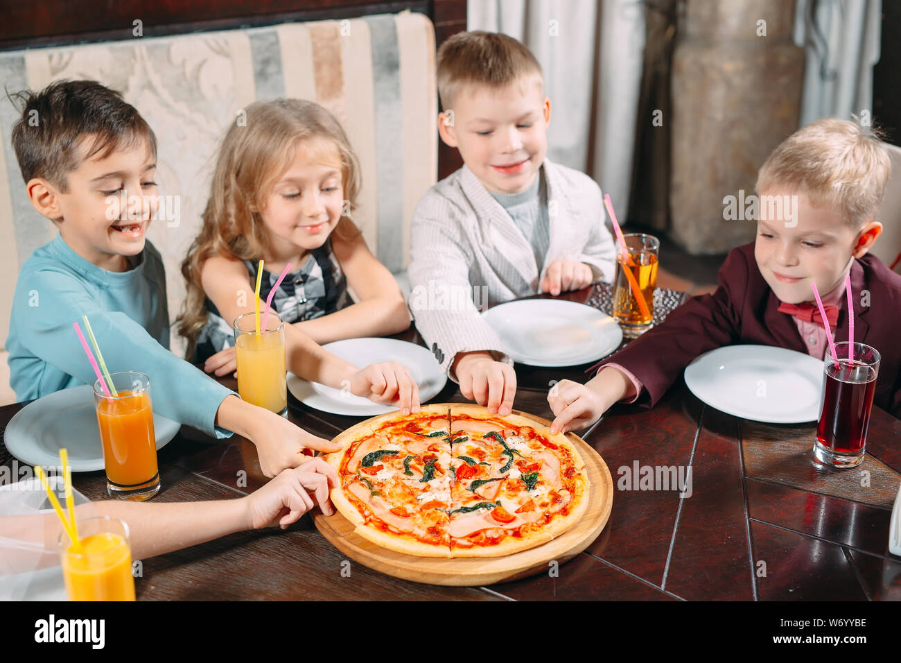 company of children eat pizza in the restaurant Stock Photo