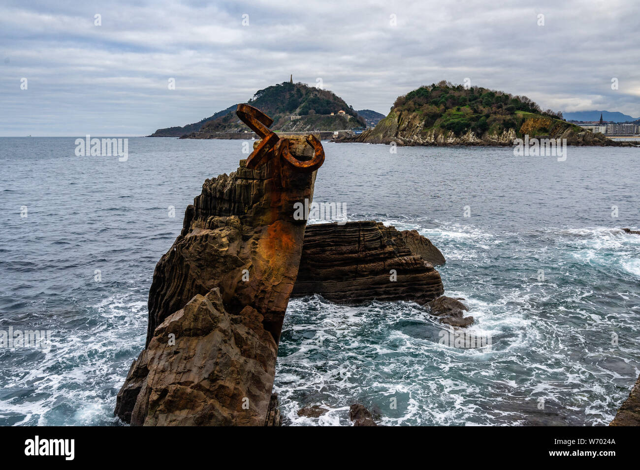Peine del Viento sculpture on a rock with La Concha bay in the background, San Sebastian, Basque Country, Spain Stock Photo