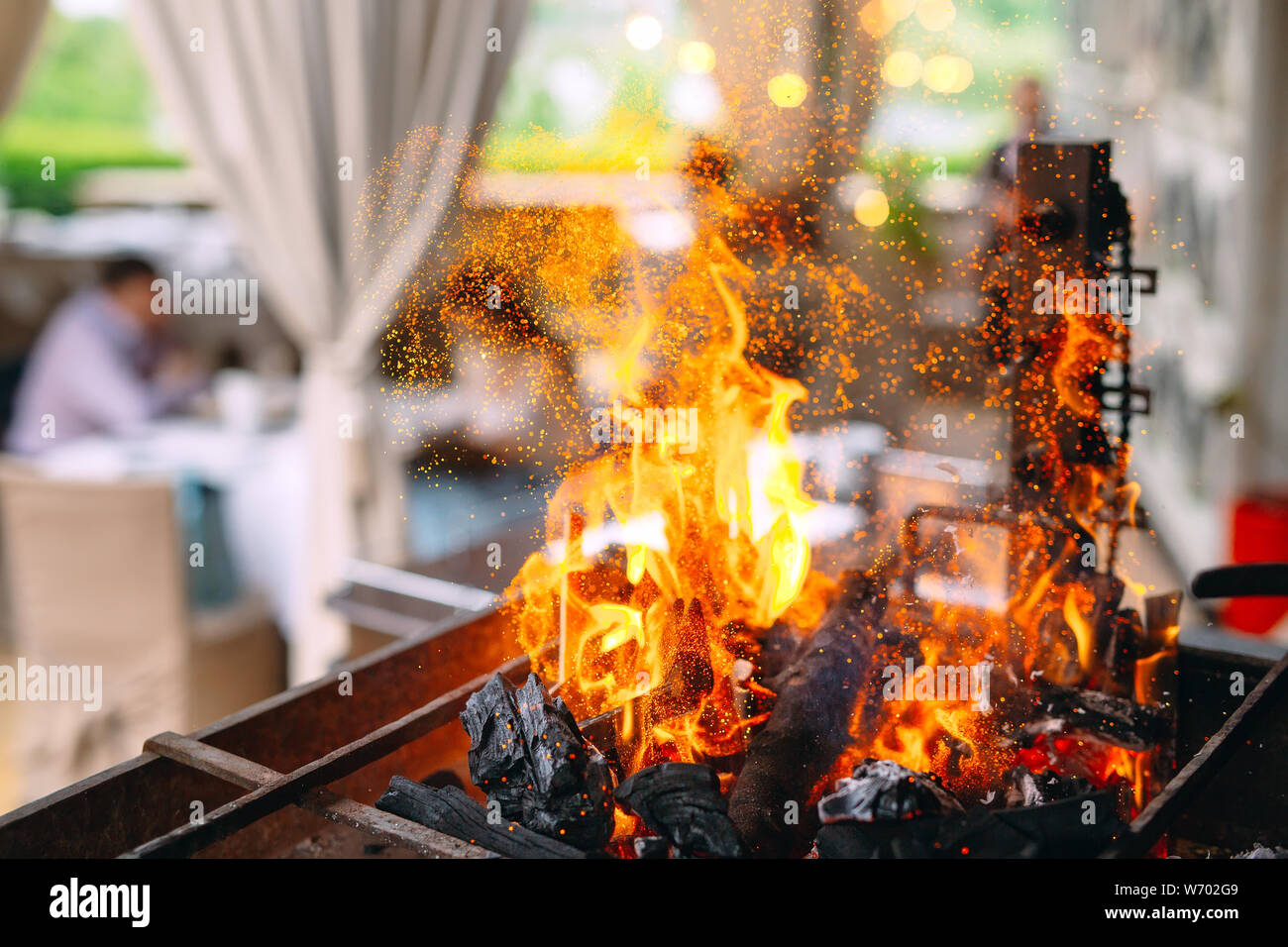 Visitors to the restaurant on the background of a burning grill Stock