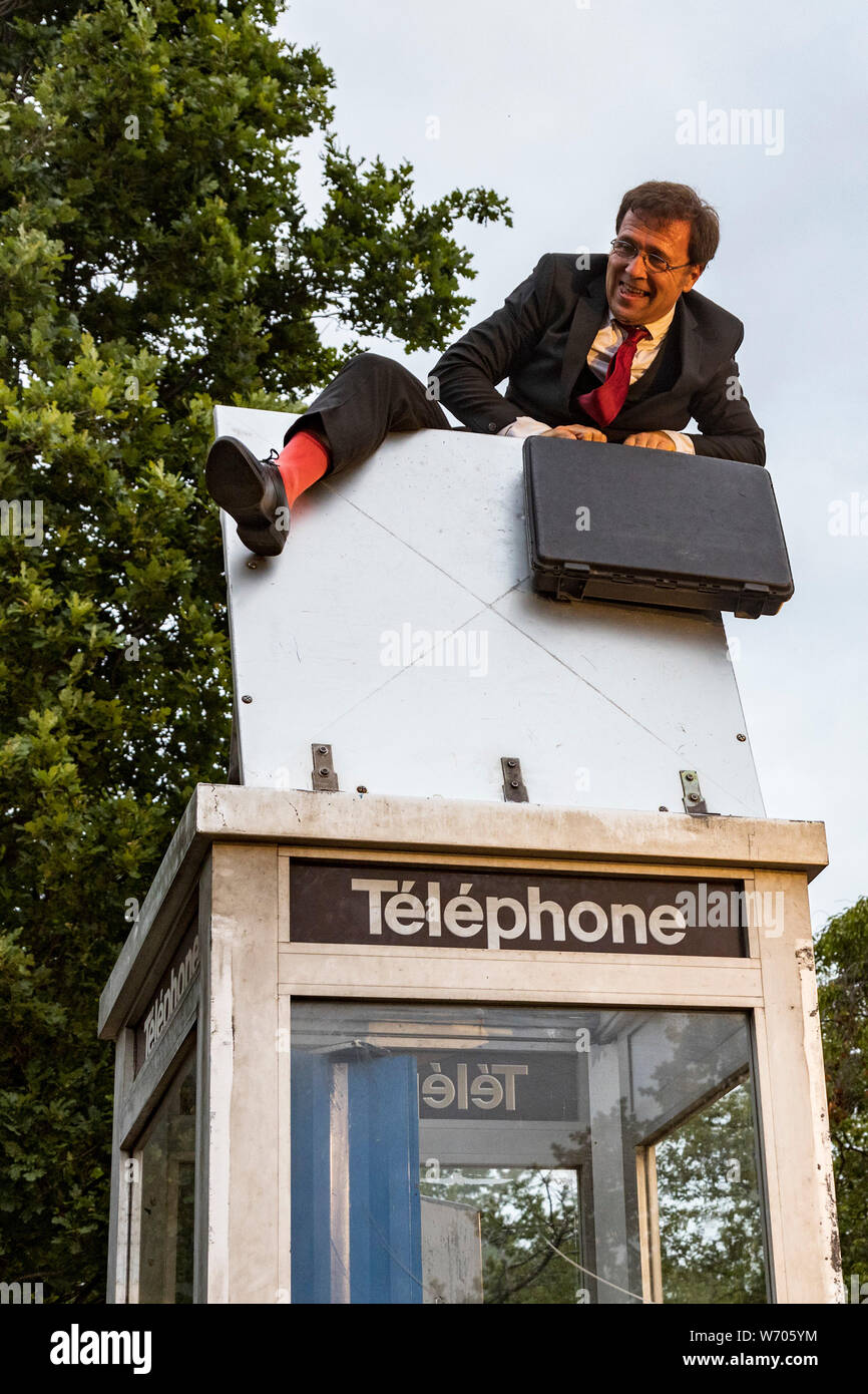 Mülheim an der Ruhr, Germany. 3 August 2019. Frenchman Ivan Chary of the Compagnie du Petit Monsieur tries to get into a closed telephone box. The 11th Broicher Schlossnacht takes places with performances ranging from dance to arts and theatre at MüGa-Park. Photo: Vibrant Pictures/Alamy Live News Stock Photo