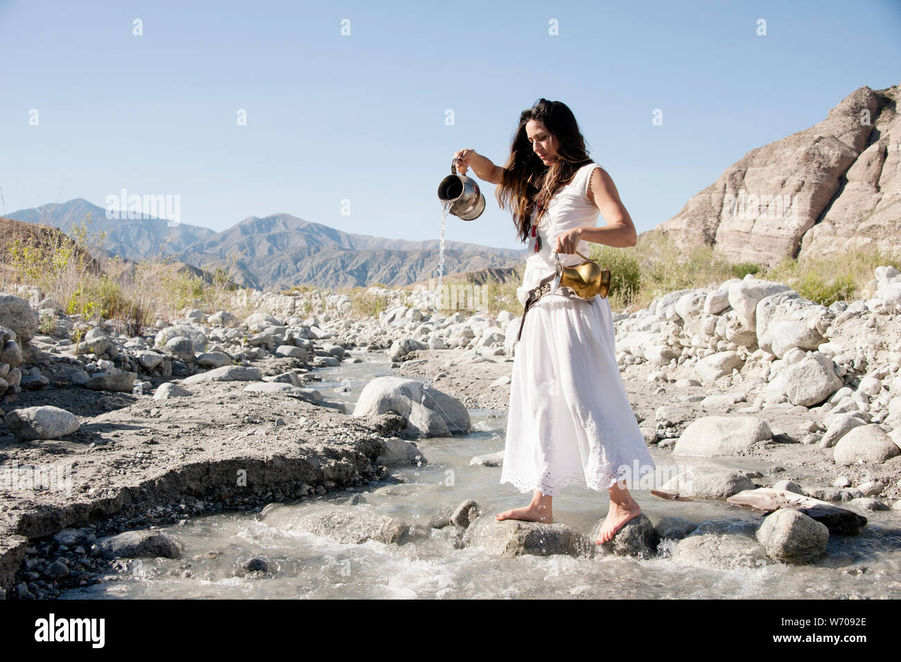 THE STAR Tarot water woman pouring from two pitchers into a wild river. You are will find yourself inspired when the Star card appears. Stock Photo