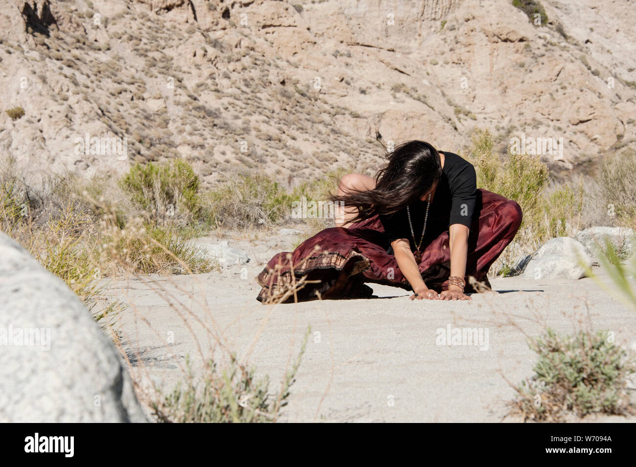 Woman grounding her energy into the wild earth. Woman grounding her energy into the wild earth. Stock Photo