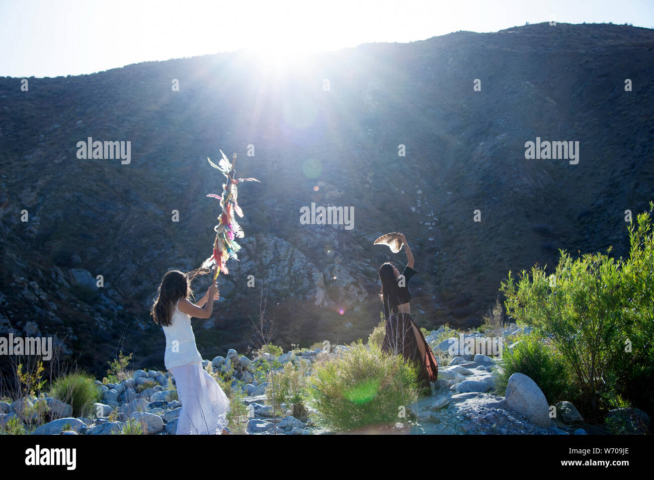 Women celebrating the land and the sun with shamanic feathers. Wild Woman Earth Celebration Stock Photo