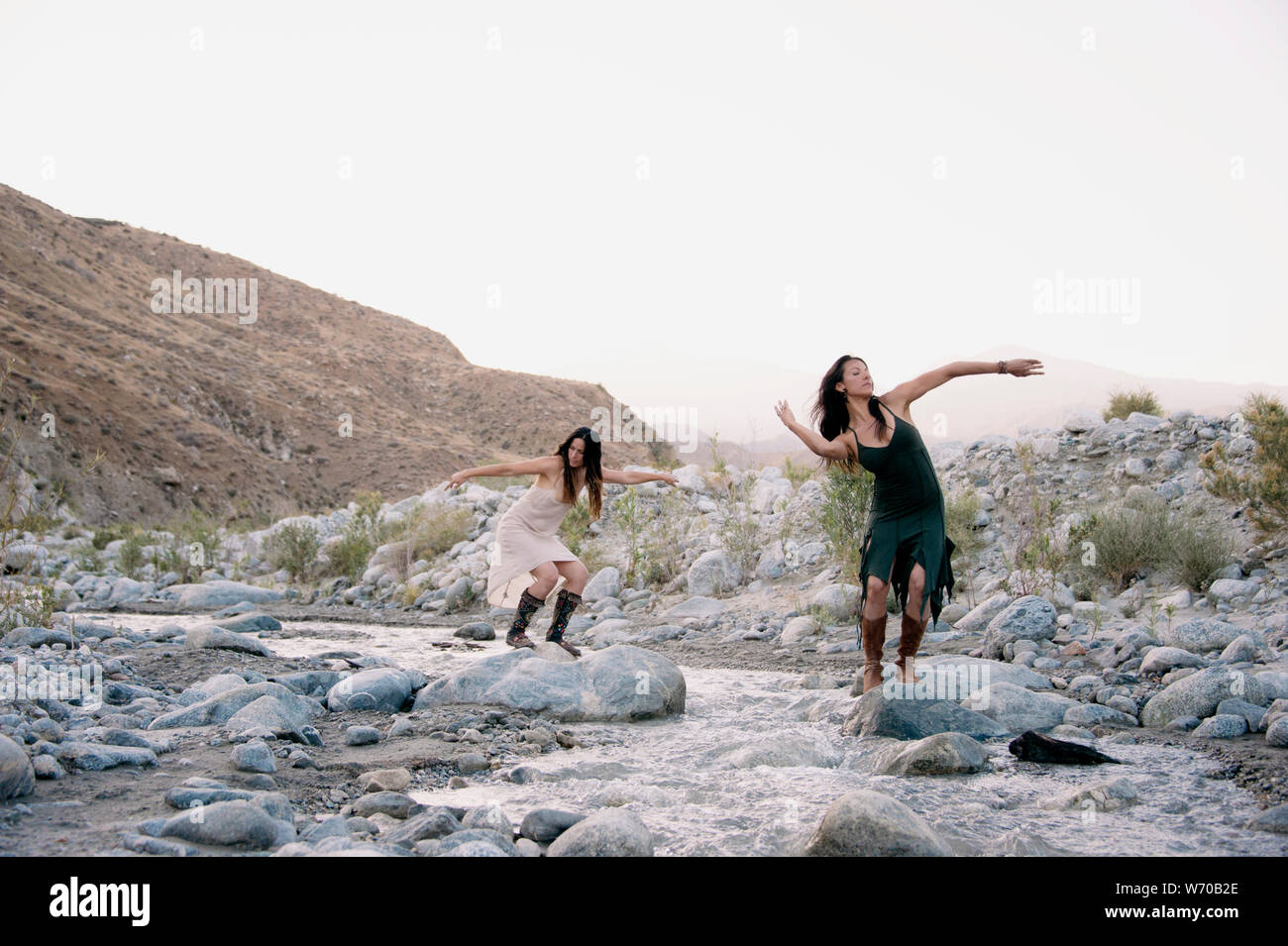 Beautiful wild women dancing freely with the desert river. Stock Photo