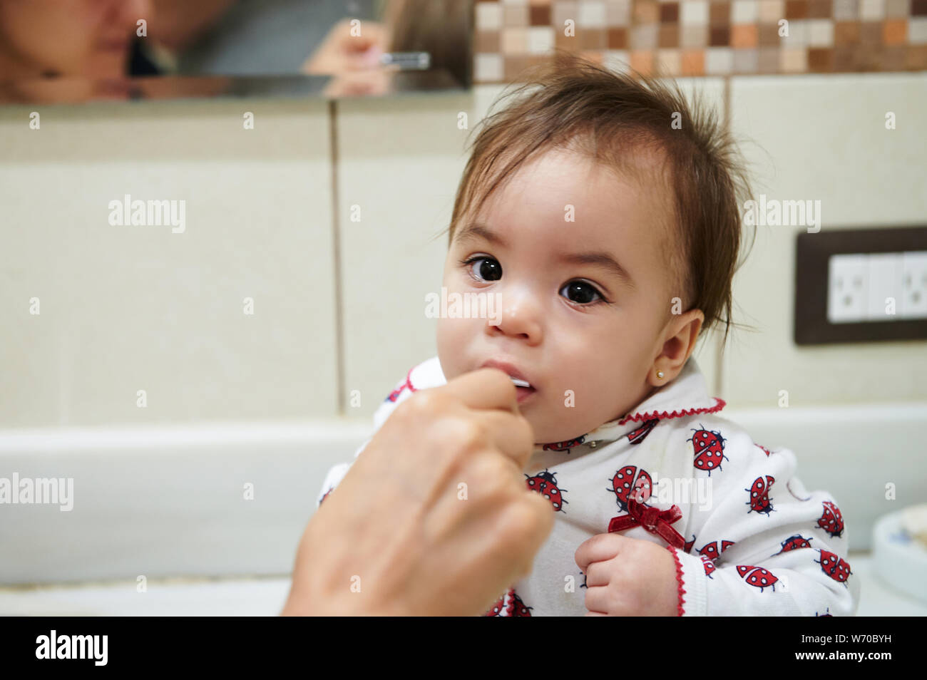 First brushing teeth experience. Portrait of baby girl brushing teeth