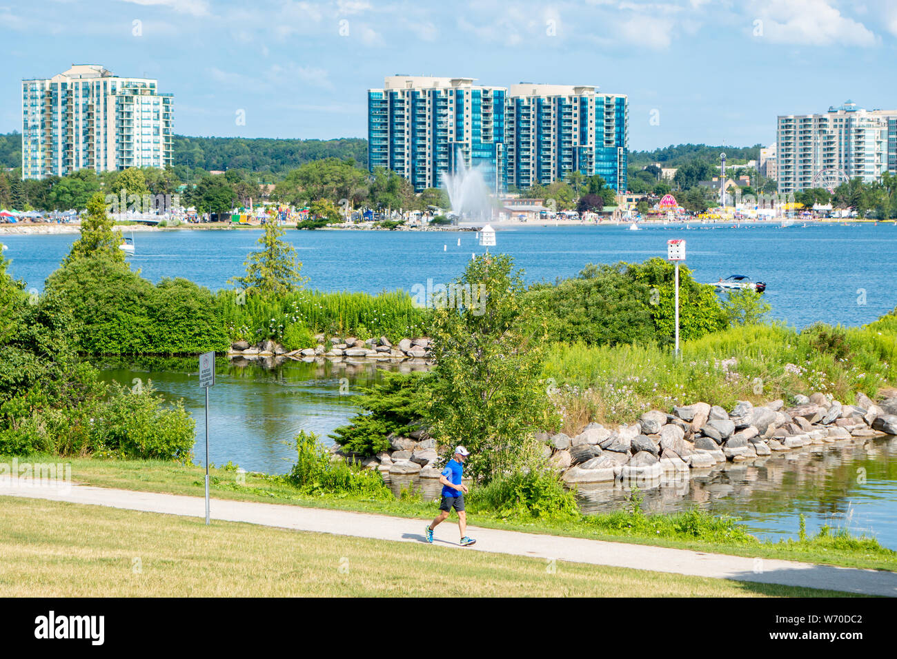 Jogger running on a path along the beautiful Barrie Ontario waterfront. Stock Photo