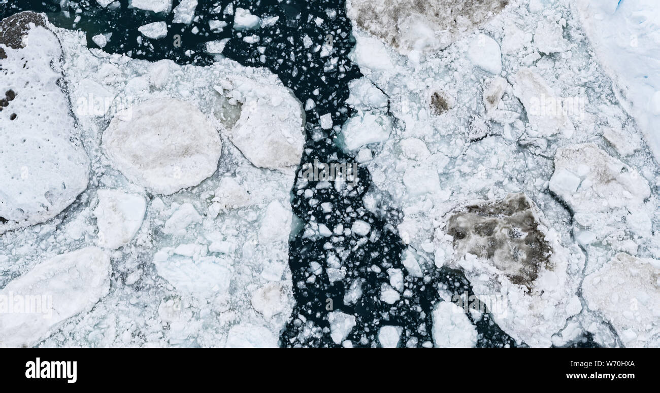 Icebergs drone aerial image top view - Climate Change and Global Warming. Icebergs from melting glacier in icefjord in Ilulissat, Greenland. Arctic nature ice landscape in Unesco World Heritage Site. Stock Photo