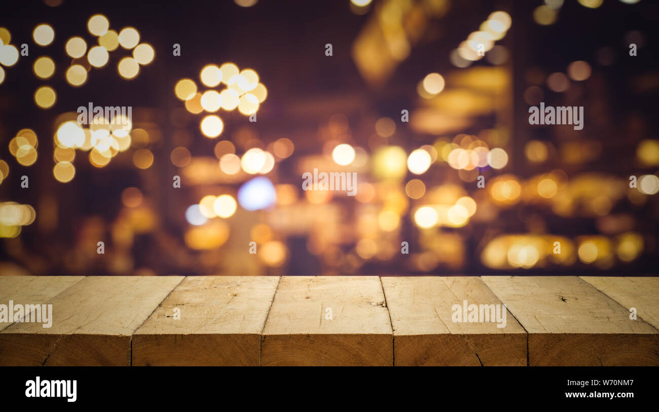 Wood table top (Bar) with blur light bokeh in dark night cafe