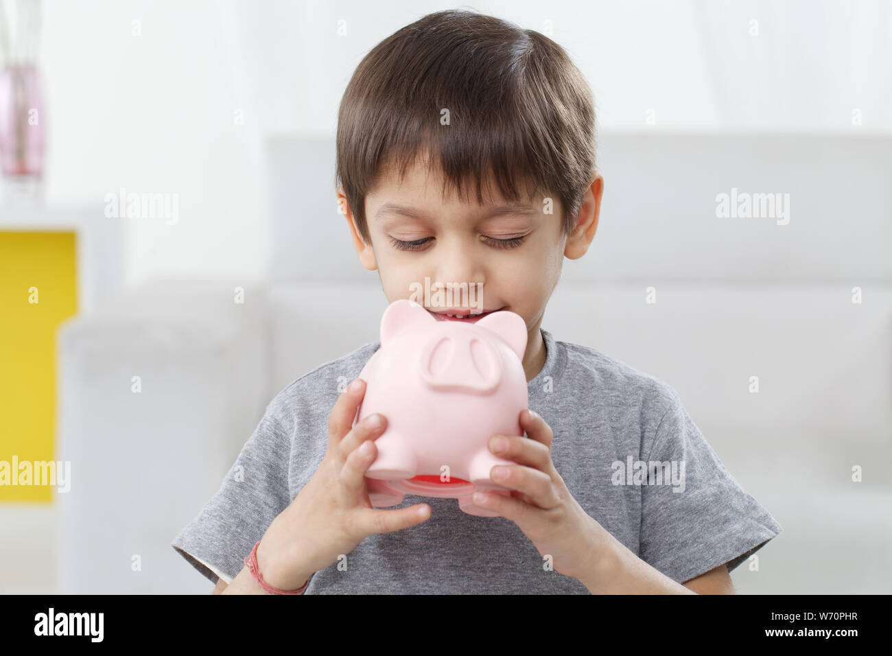 Boy holding a piggy bank and smiling Stock Photo