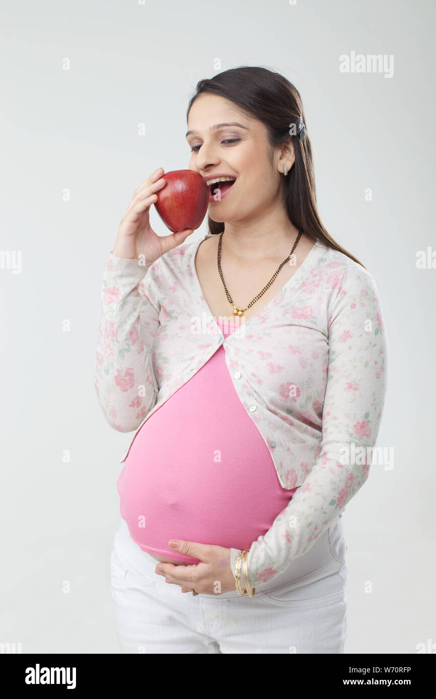 Pregnant woman eating an apple Stock Photo Alamy