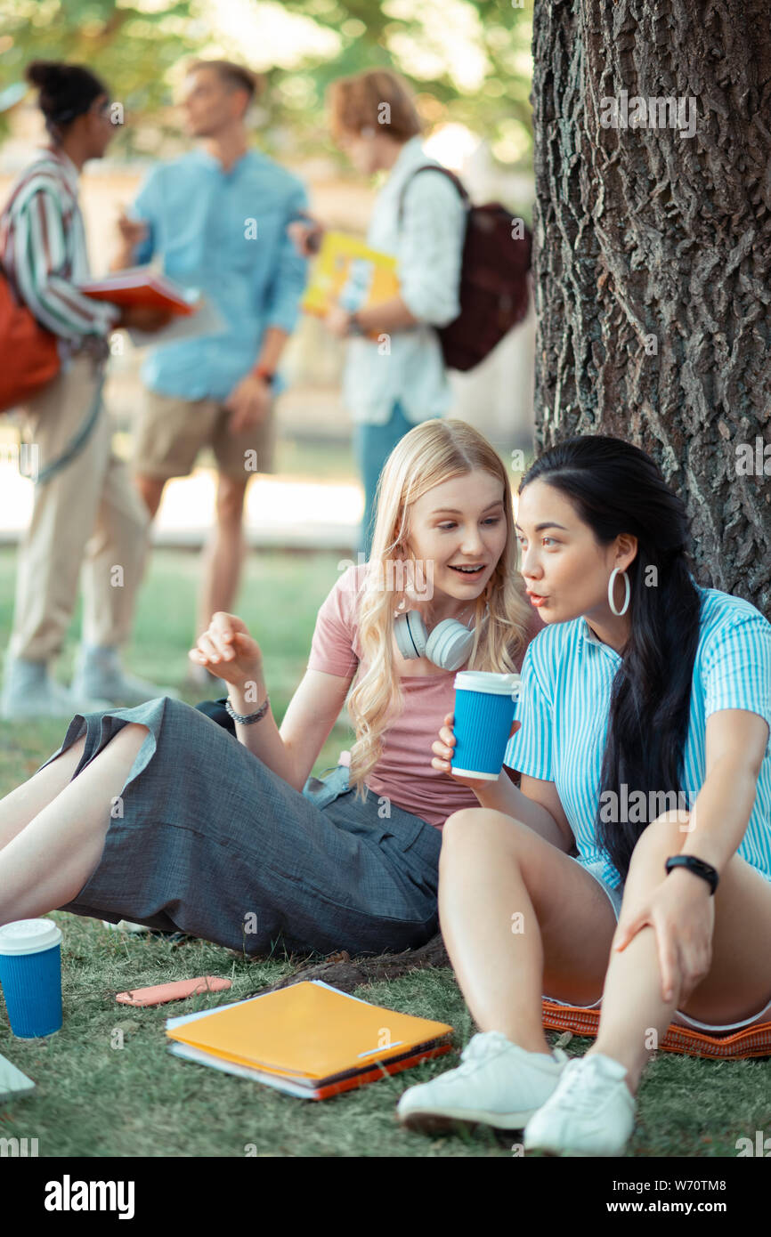 Two girls talking about their latest news Stock Photo - Alamy